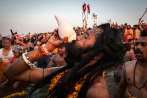 Naga Sadhu Blowing Into a Conch Shell at Kumbh Mela Festival in Allahabad (Prayagraj), Uttar Pradesh, India